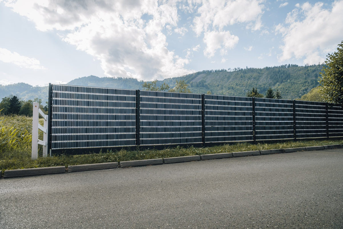 Langer Sunbooster VERTICAL+ Solarzaun an einer Zufahrt