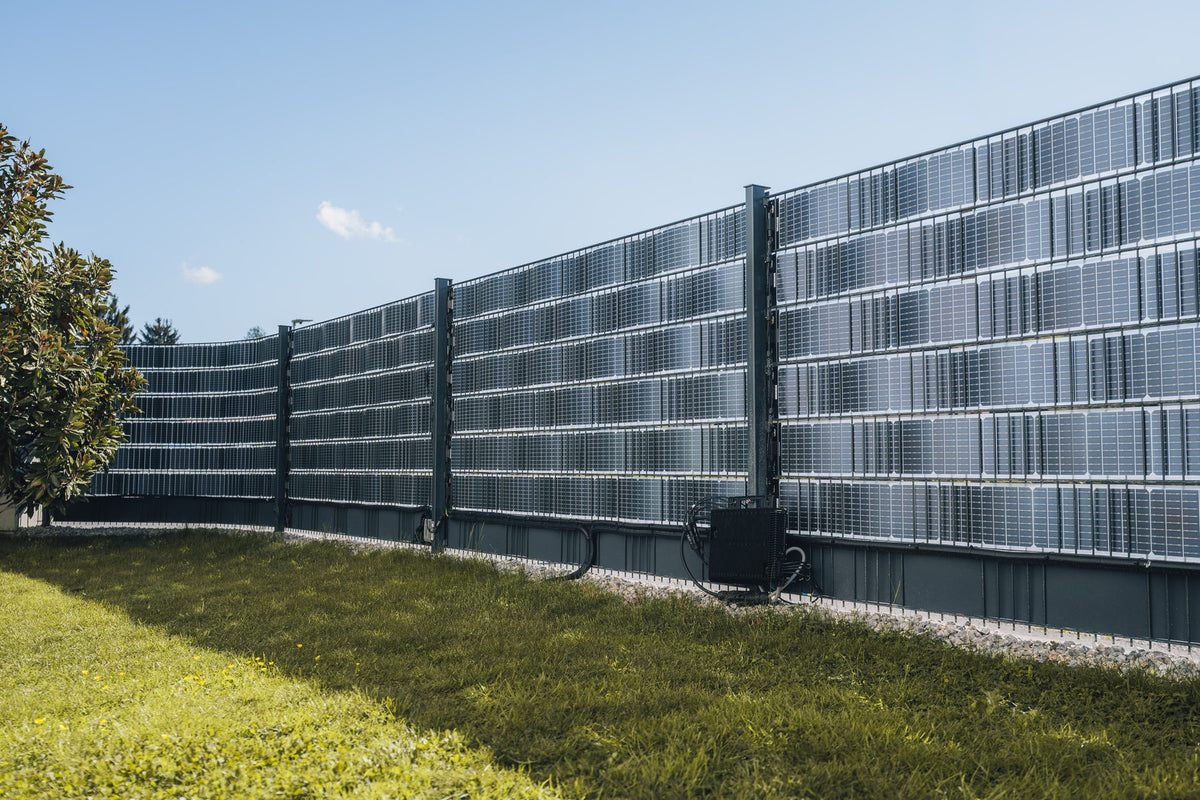 Sunbooster VERTICAL+ Solarzaun auf einer Wiese unter blauem Himmel