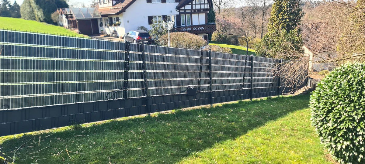 Sunbooster VERTICAL+ Solarzaun an einer Rasenfläche