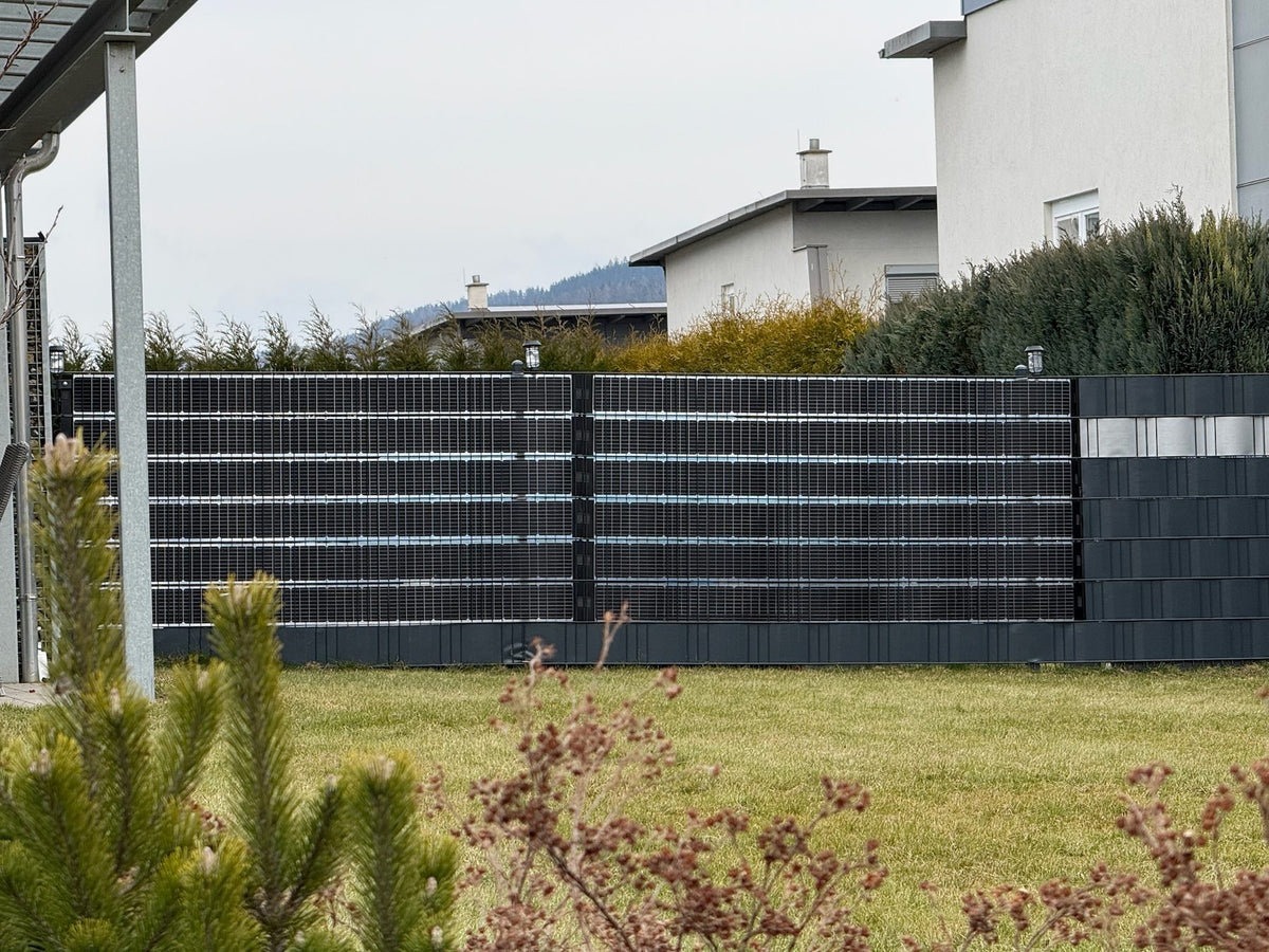 Sunbooster VERTICAL+ Solarzaun vor einem Wohnhaus
